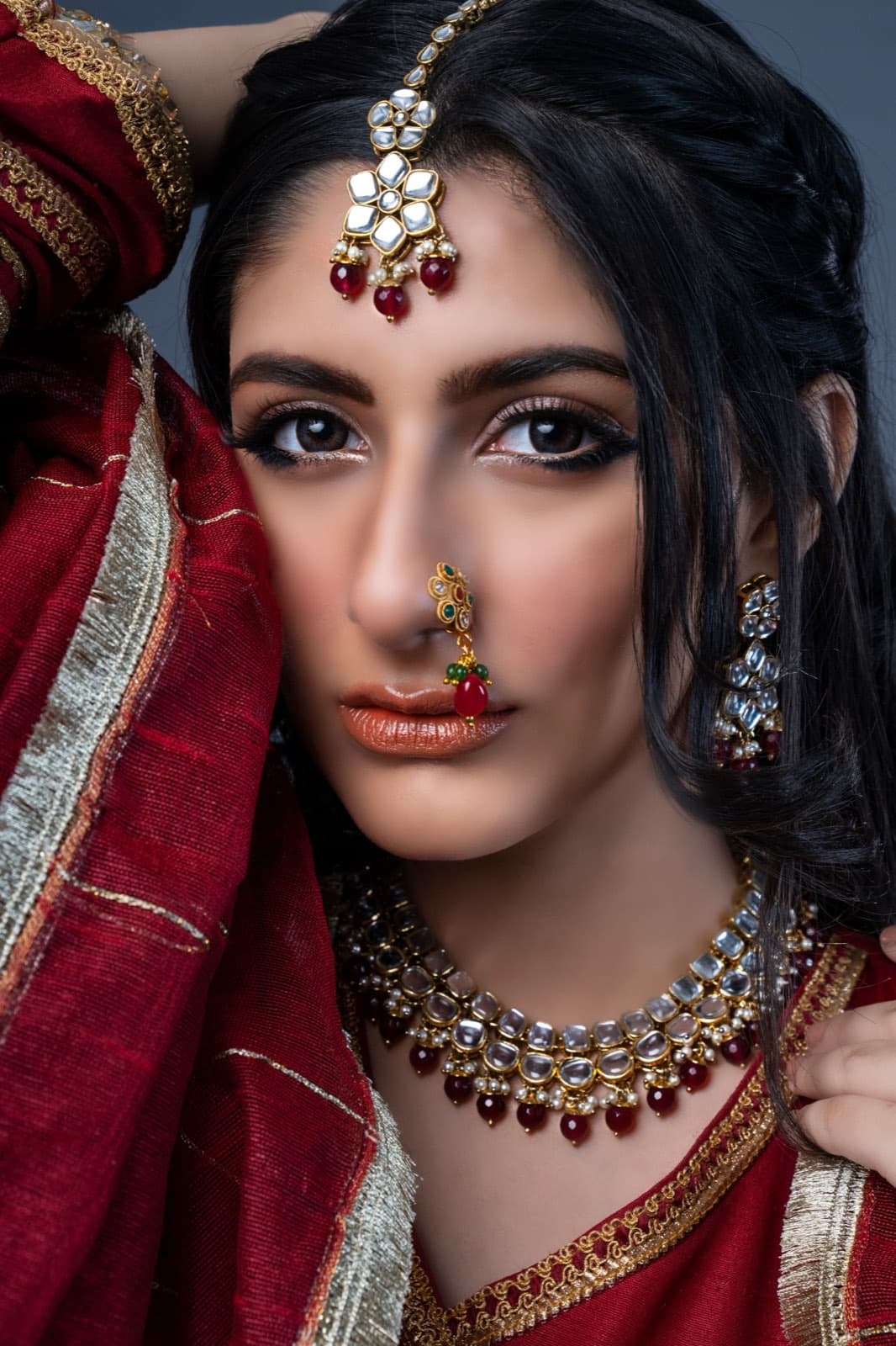 Aisha Rahman in red and gold with jewels